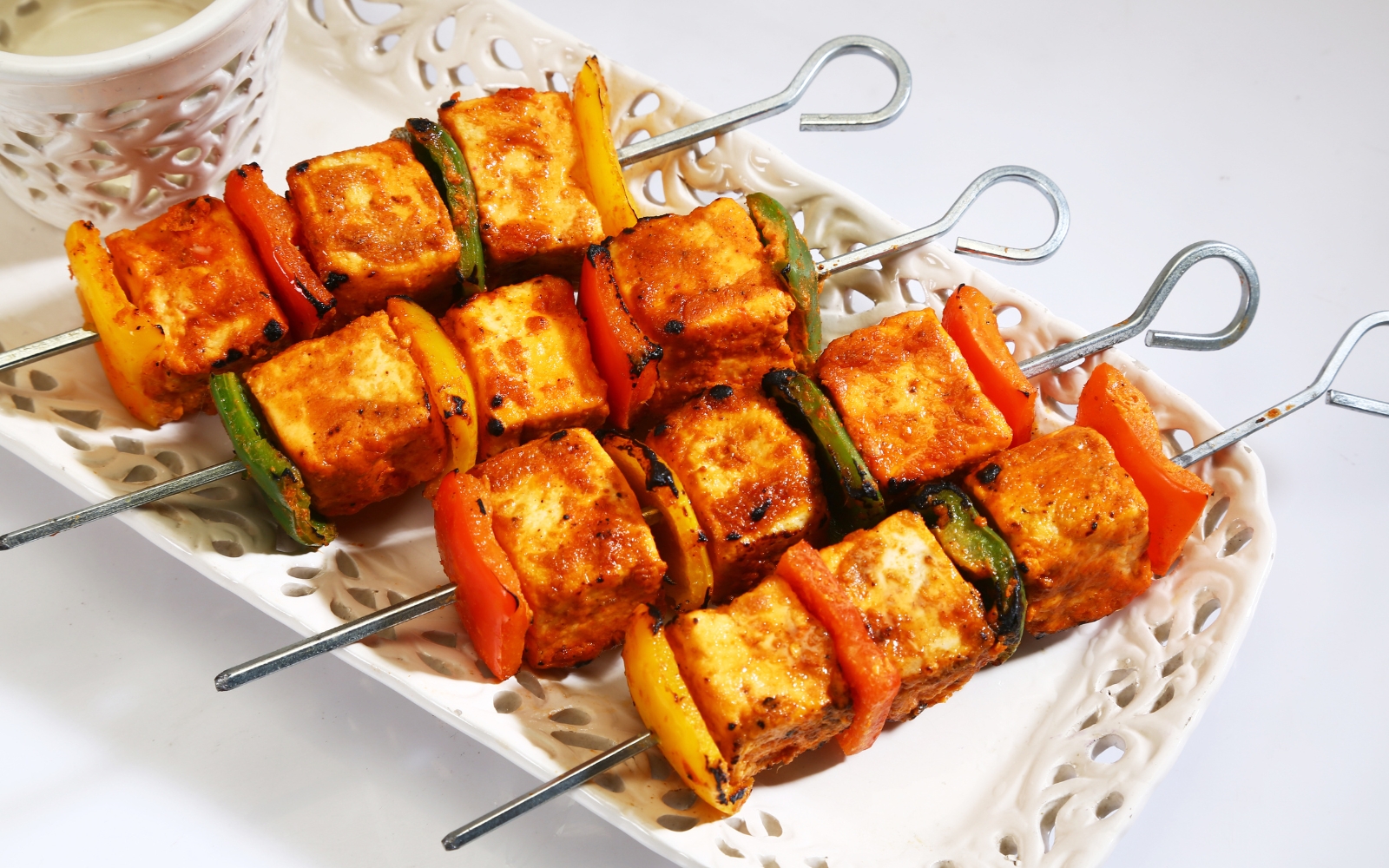 A vibrant festive table featuring Indian cuisine like Butter Chicken, Paneer Tikka, and Tandoori Chi